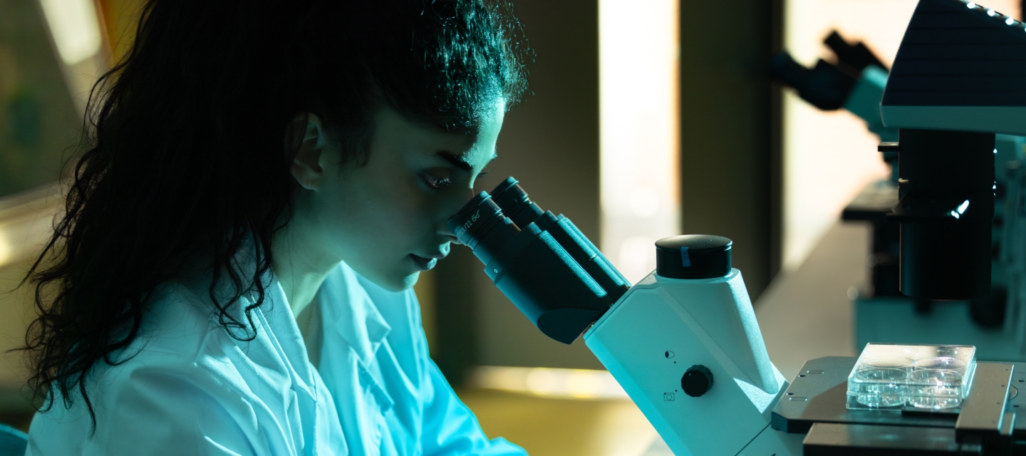 student looking through microscope